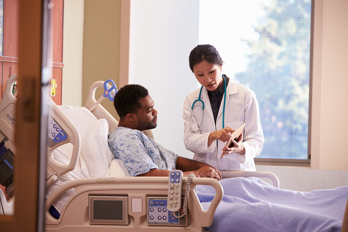 A pharmacist chats with a patient about his medications during a check-up visit.