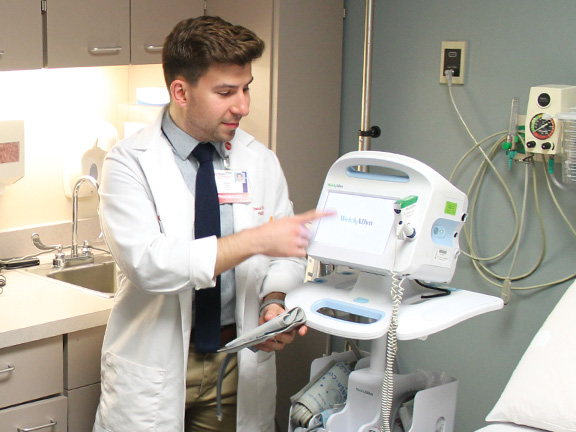 A hospital pharmacist adjusts a monitor.