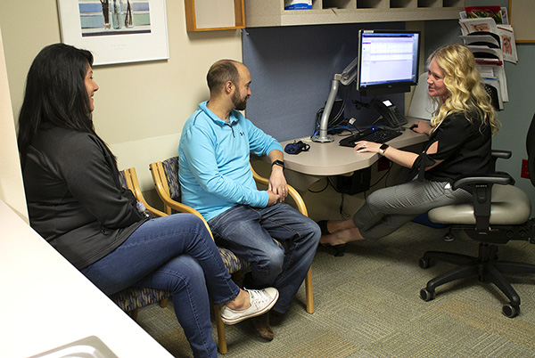 A pharmacist chats with a patient about his medications during a check-up visit.